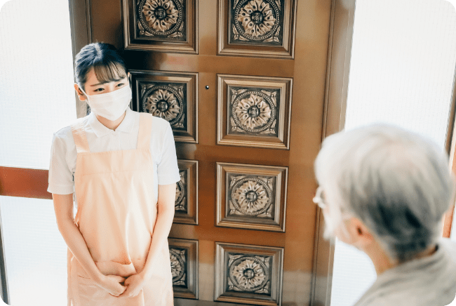 掃除代行サービスの女性が高齢の女性と話している様子